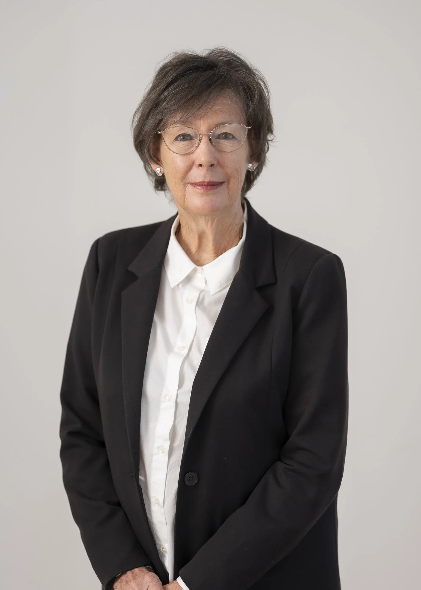 Portrait of Gaye Tozer, Trustee, smiling against a neutral grey background.