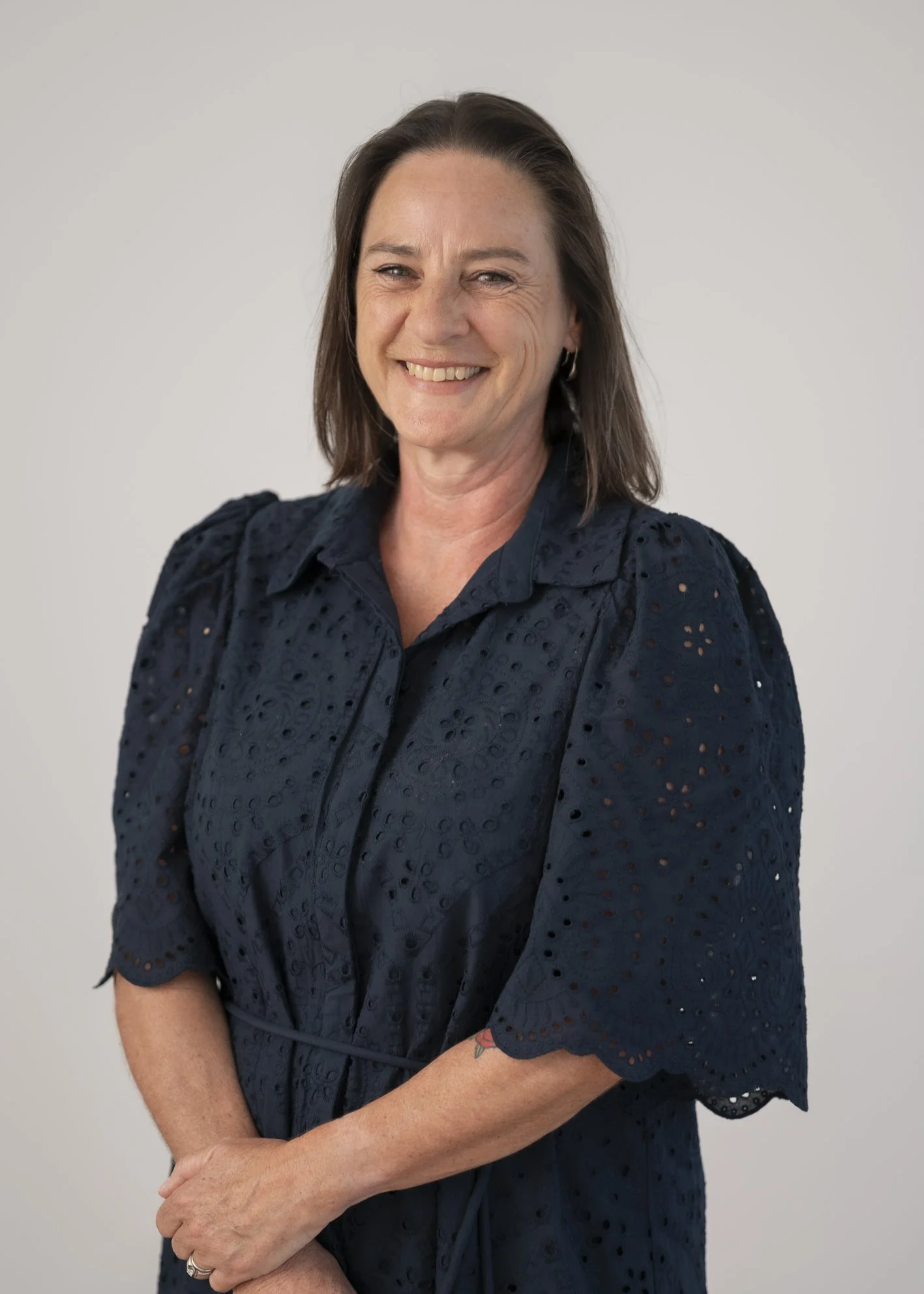 Portrait of Rebecca Tomczyk, Practice Coordinator, smiling against a neutral grey background.
