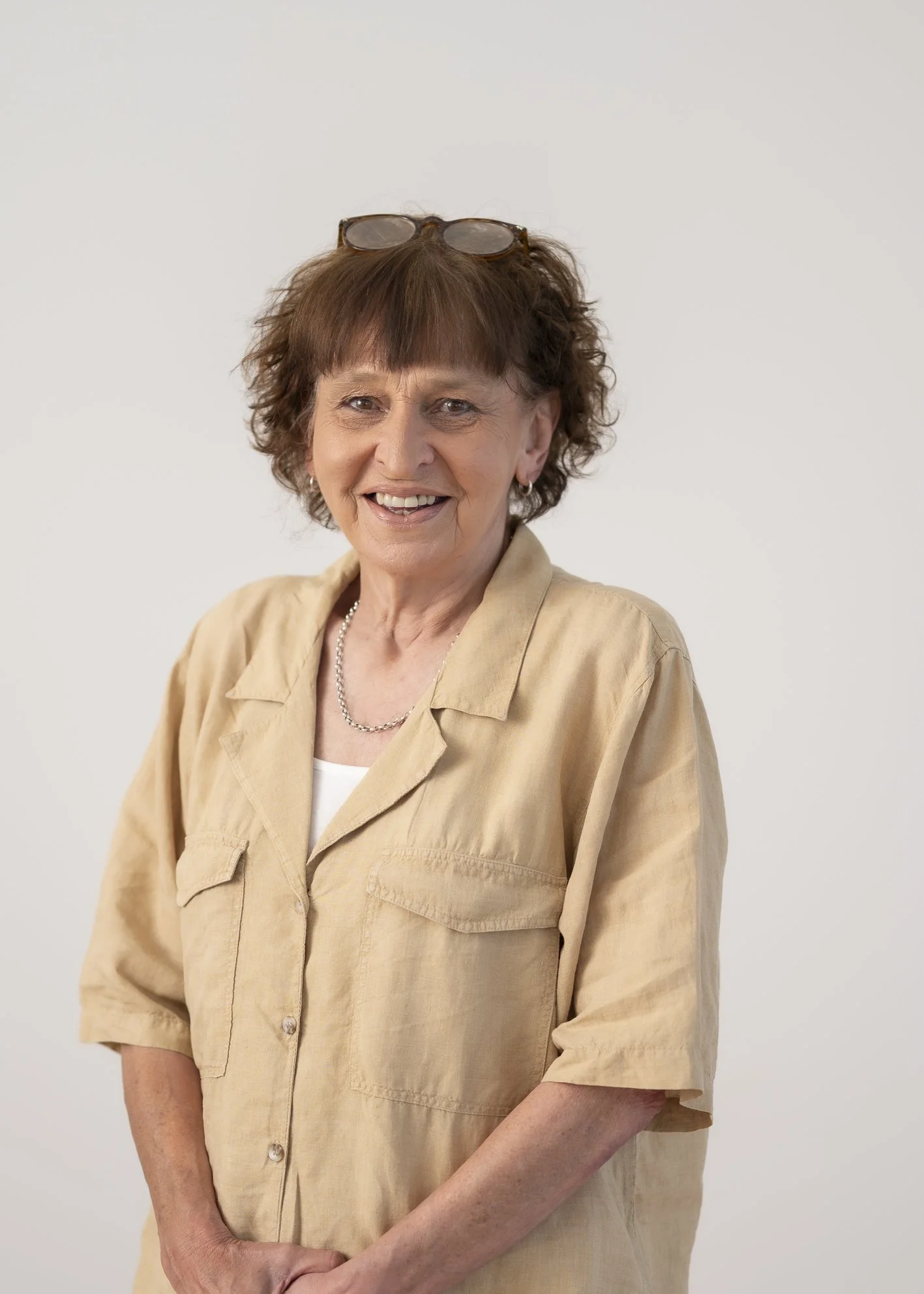 Portrait of Catherine Moller, Administrator, smiling warmly against a neutral grey background.