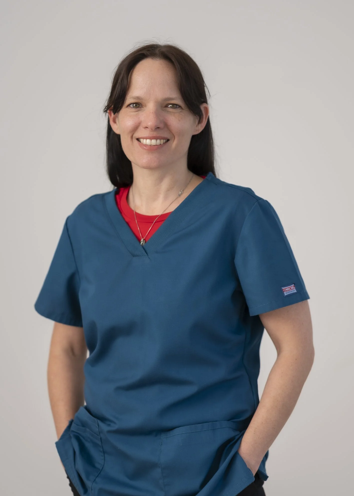 Portrait of Analia Crespo, Health Care Assistant, smiling in teal scrubs.