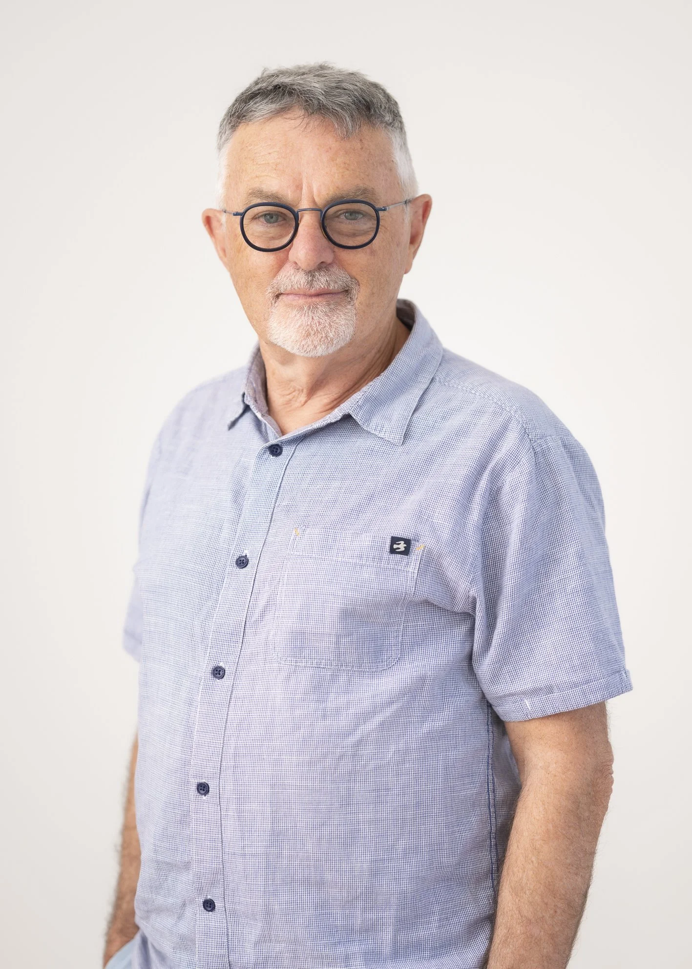 Portrait of Peter Reilly, Trustee, standing against a neutral grey background.