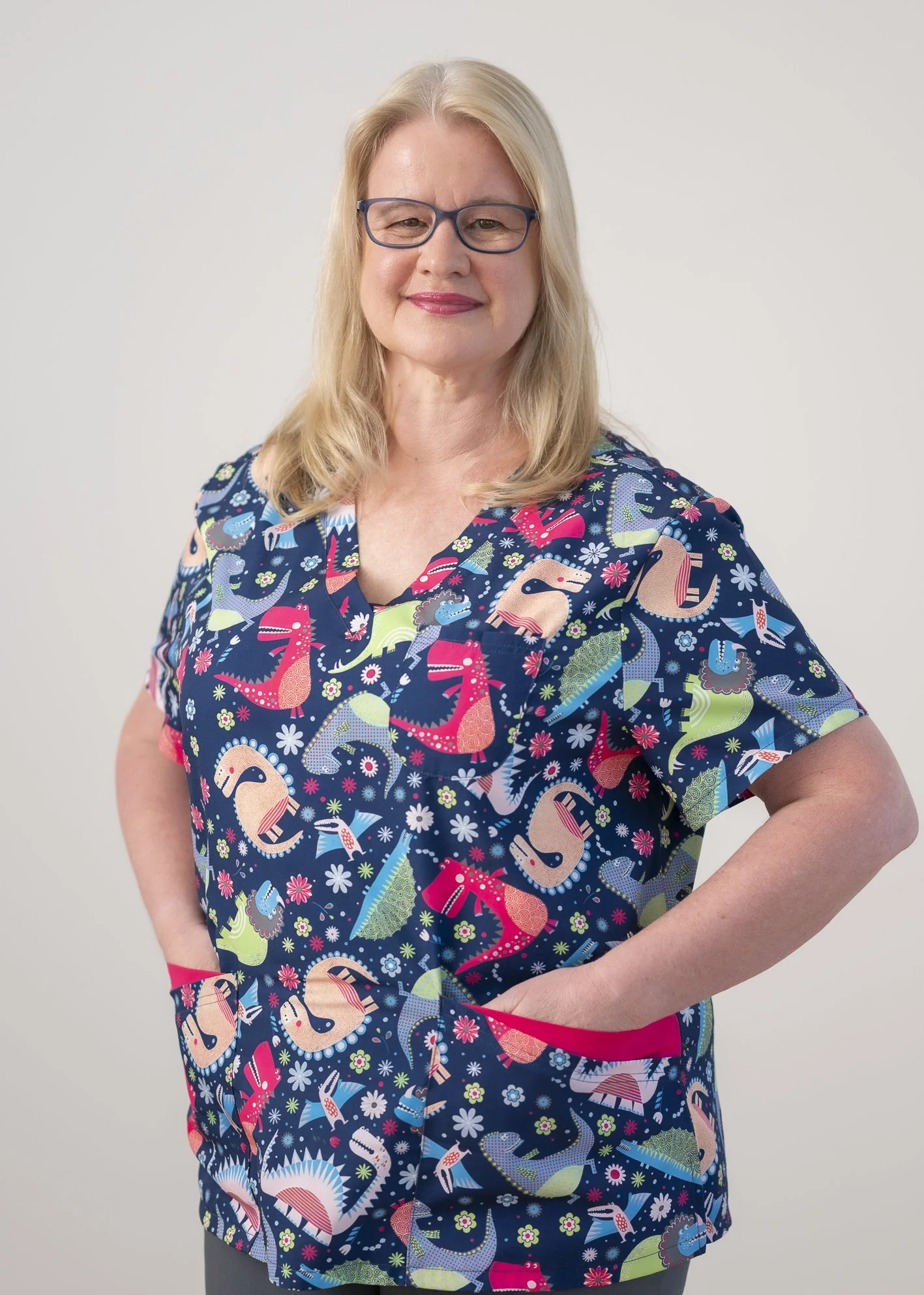 Portrait of Kirsten Sloan, Well Child Tamariki Ora Nurse, smiling warmly. Natural lighting and a caring expression help convey trust, professionalism and community-focused care. Standing against a plain light grey background.