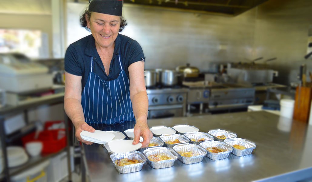 A photo of the Waiheke Meals on Wheels containers being prepared and served in the kitchen.