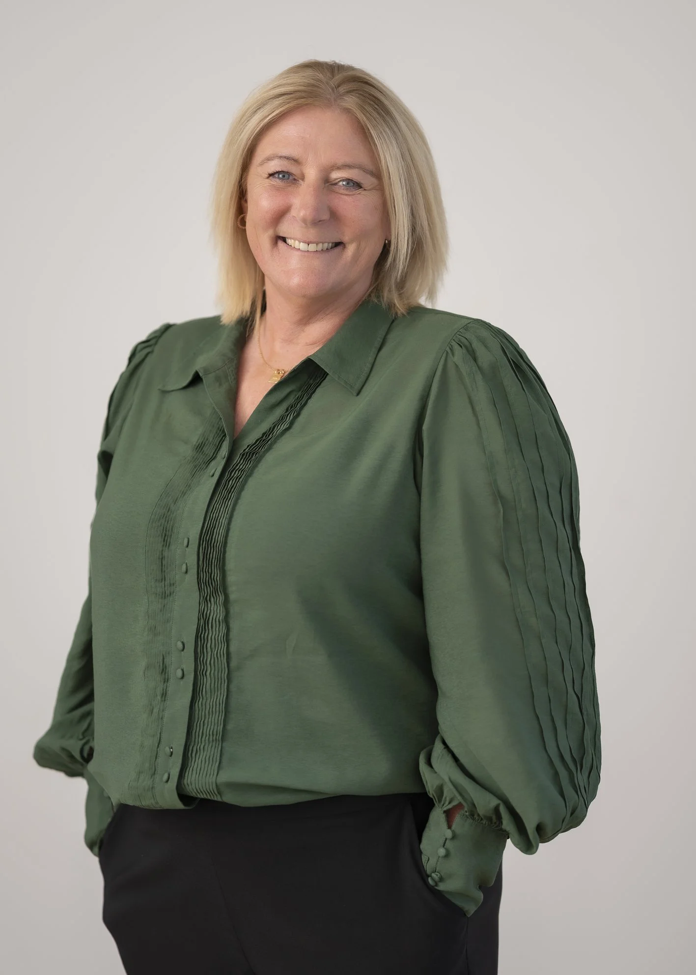 Portrait of Kylee Greacen, Medical Receptionist, smiling against a neutral grey background.