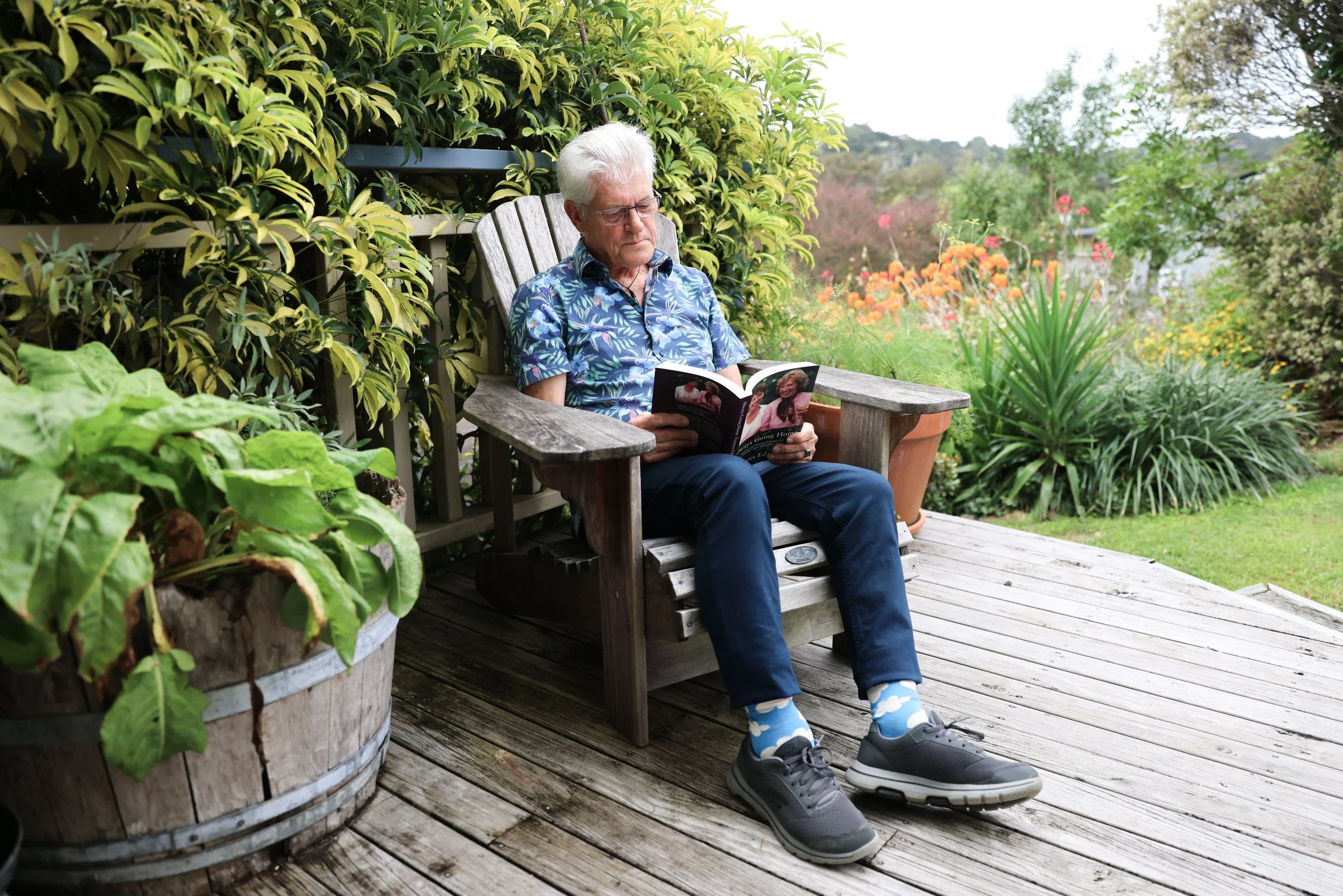 A image of a man reflecting in his chair reading a book on his loved ones