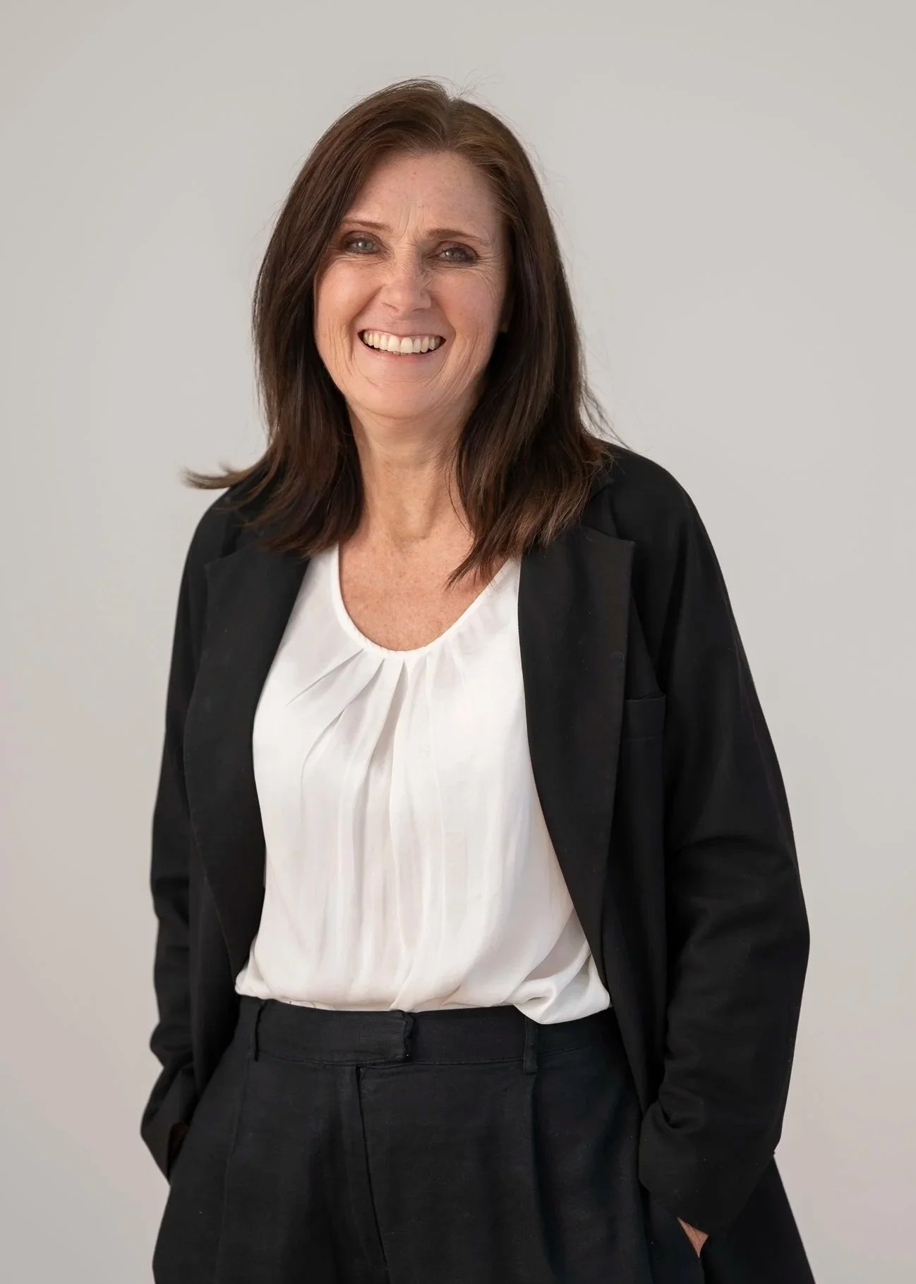 Portrait of Vicki Howes, Accounts Administrator, smiling warmly against a neutral grey background.