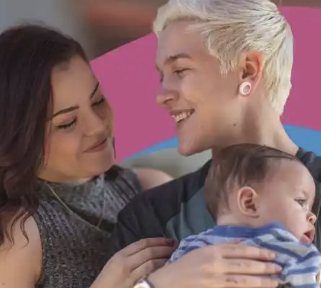 Three people, two women and one child, are depicted in close-up, smiling and holding each other in a warm, affectionate moment.