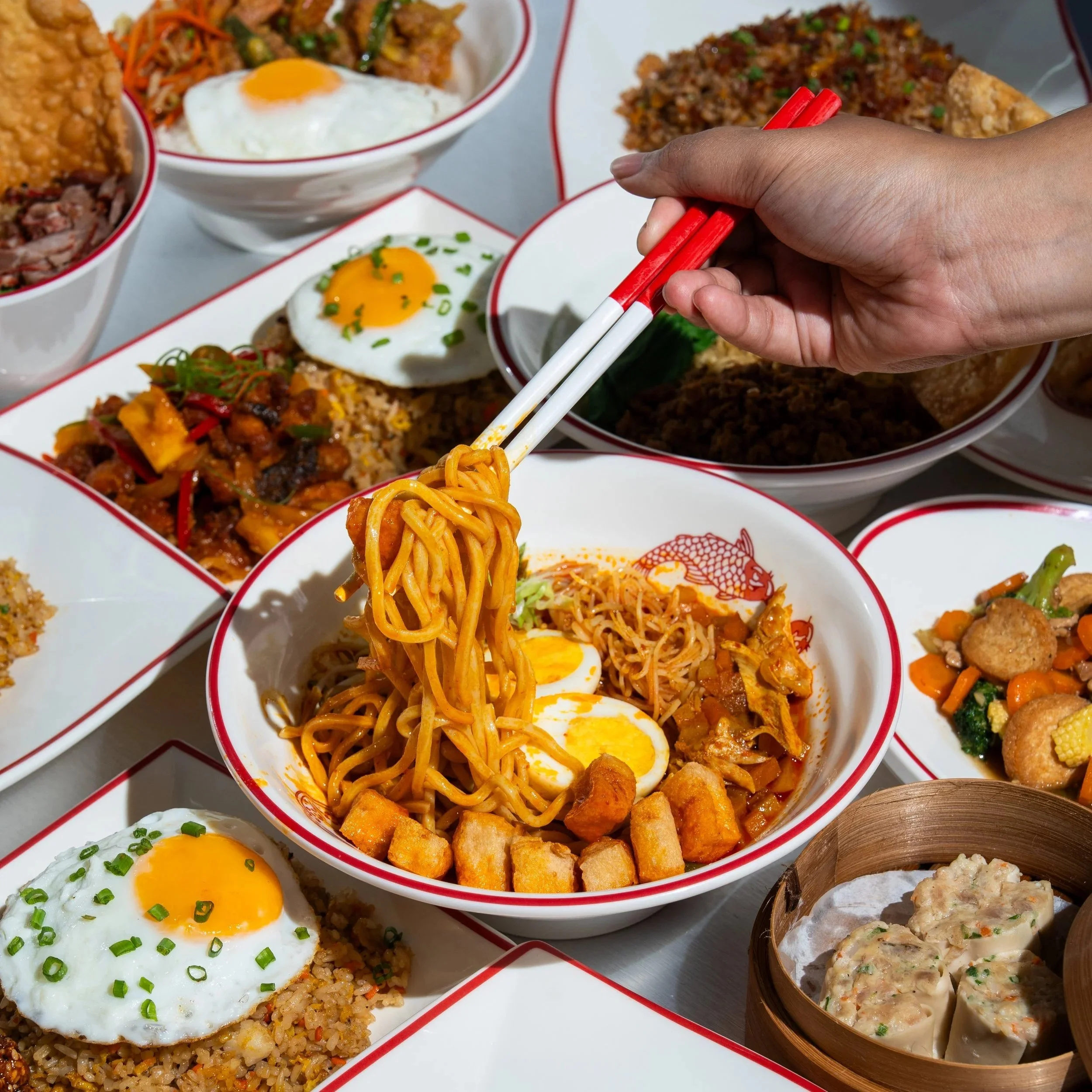 Action shot of a noodle lift featuring smoky Lo Mein at WOK This Way, the best Chinese food in Canggu.