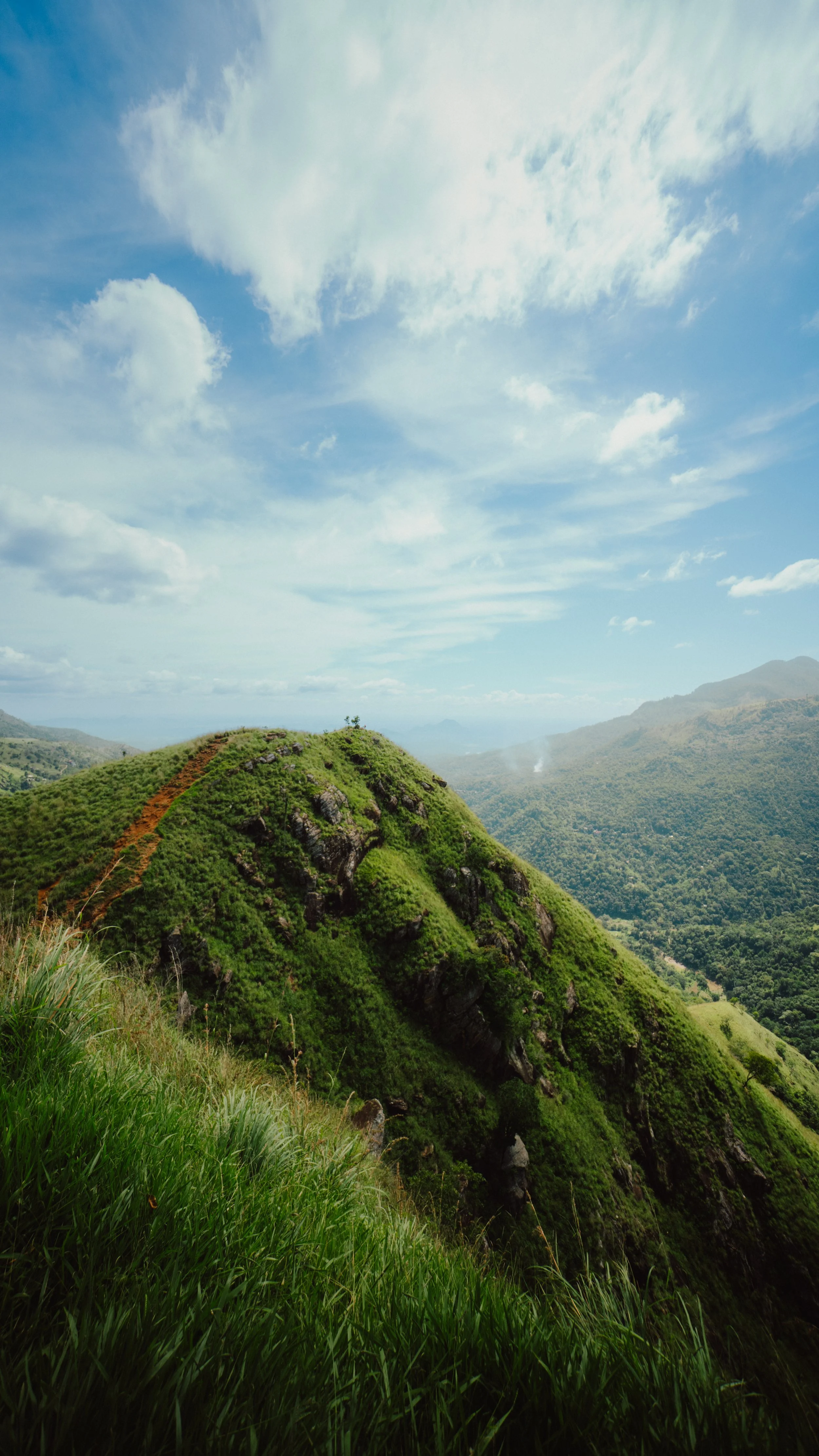 Berg mit grüner Vegetation unter einem bewölkten Himmel