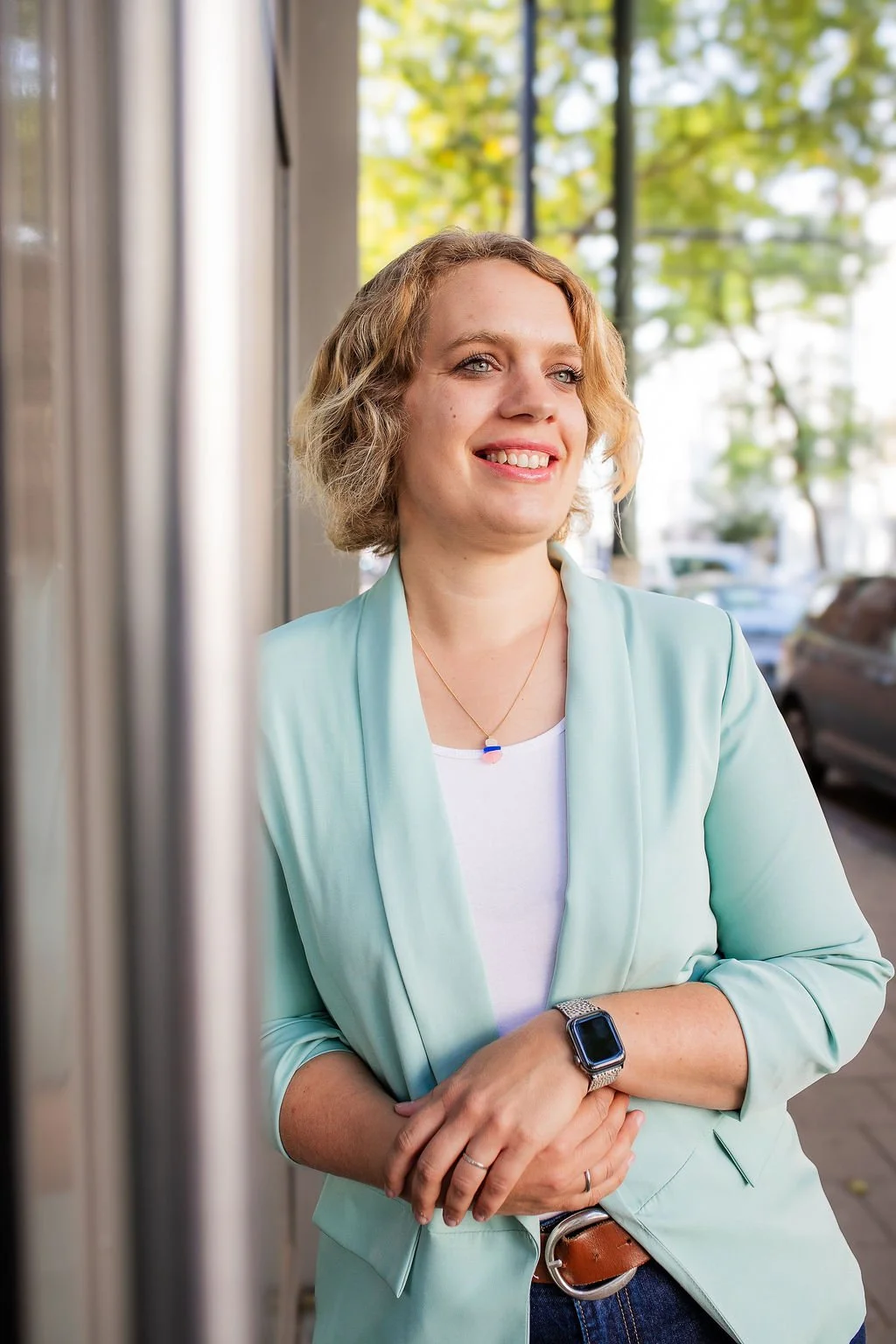 seitliches Oberkörper-Porträt von Meike Hilgemann, angelehnt an eine Hauwand.