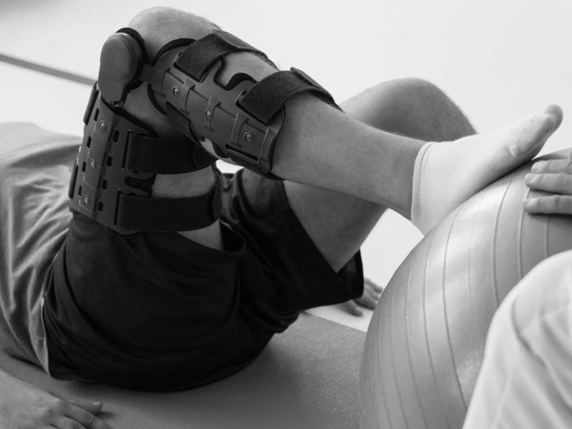 A person with a prosthetic leg doing a single leg exercise with a fitness ball.