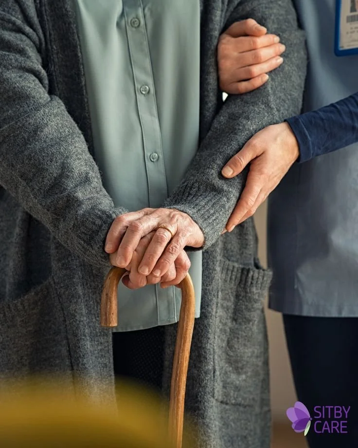 Close-up of two people holding hands, one with a cane, in a supportive gesture at a healthcare or assistance facility.