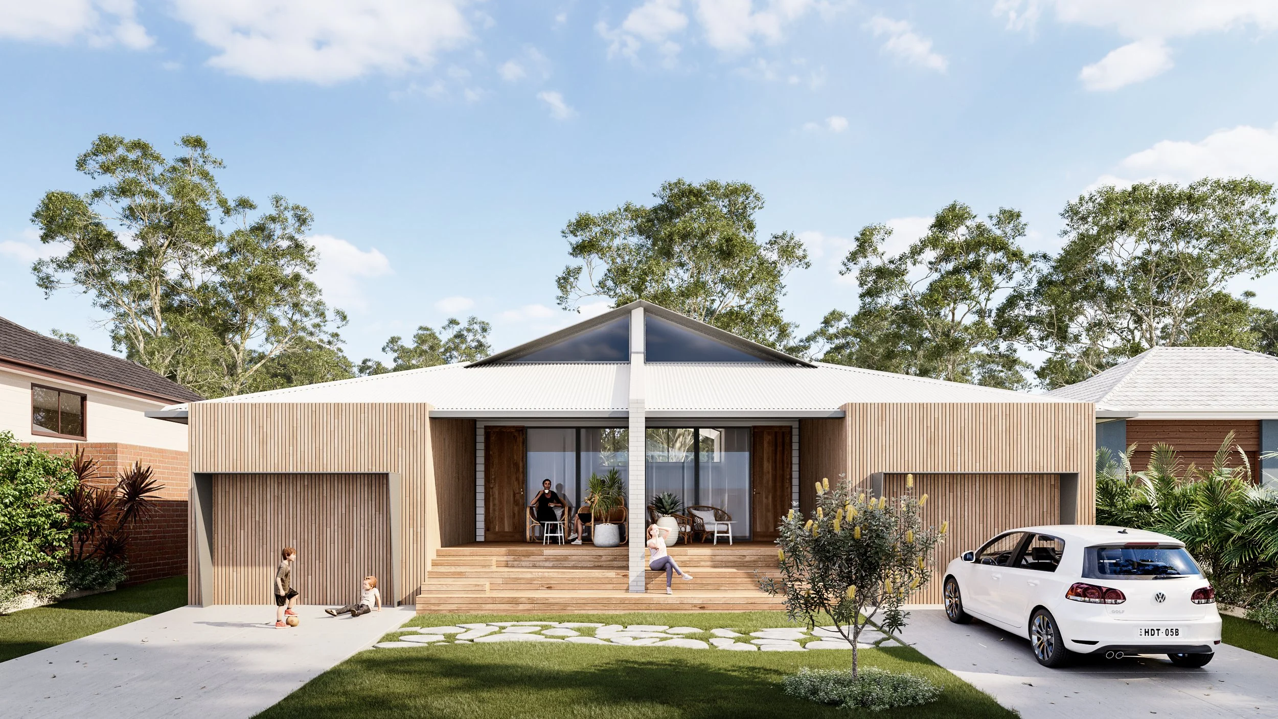 Modern house with wooden facade, front porch with seating, children playing in yard, and a white car parked in driveway under trees against blue sky.