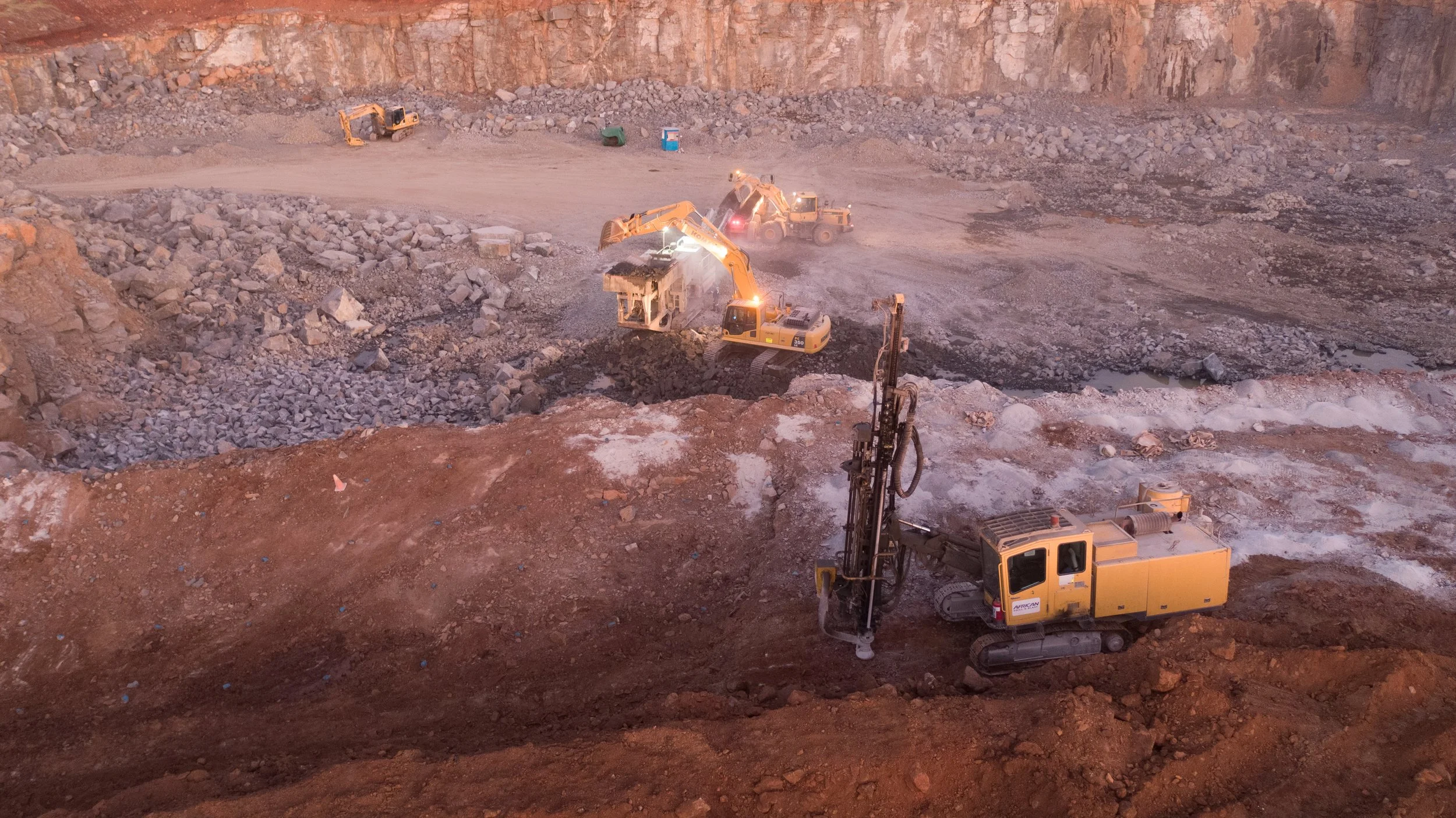 Construction site with excavators working on earth and rocks.