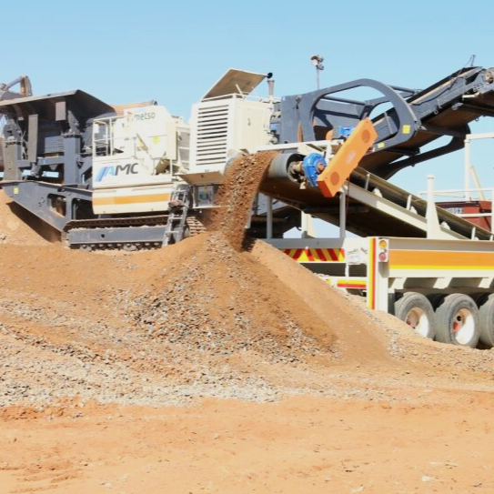 A gravel conveyor machine dumping dirt onto a pile on a construction site.