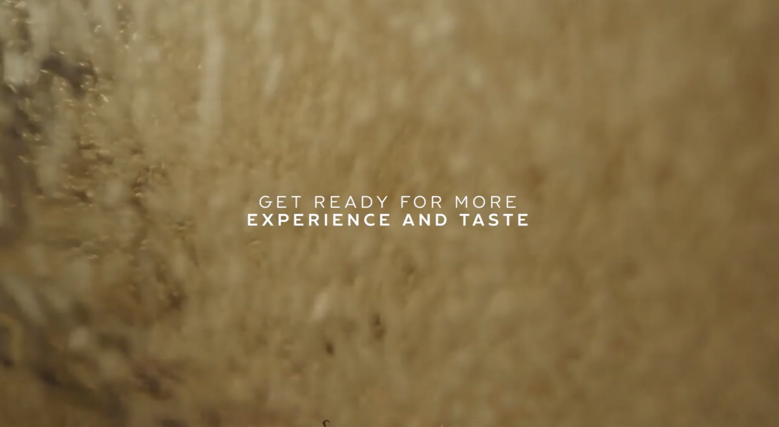 Close-up of a frothy, golden beer with the text "Get ready for more experience and taste" overlaid.