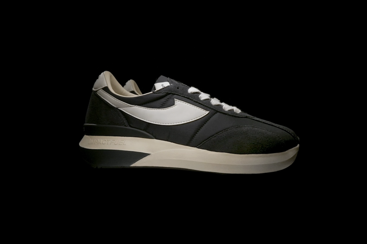 Black and white Nike sneaker on a black background.