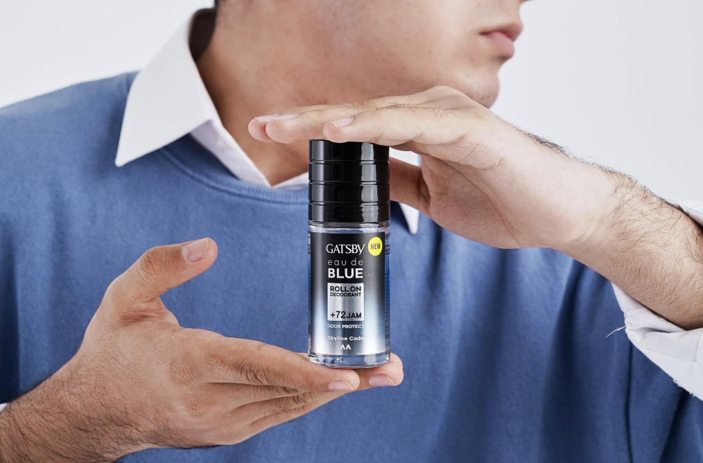 Person holding a bottle of Gatsby Blue roll-on deodorant