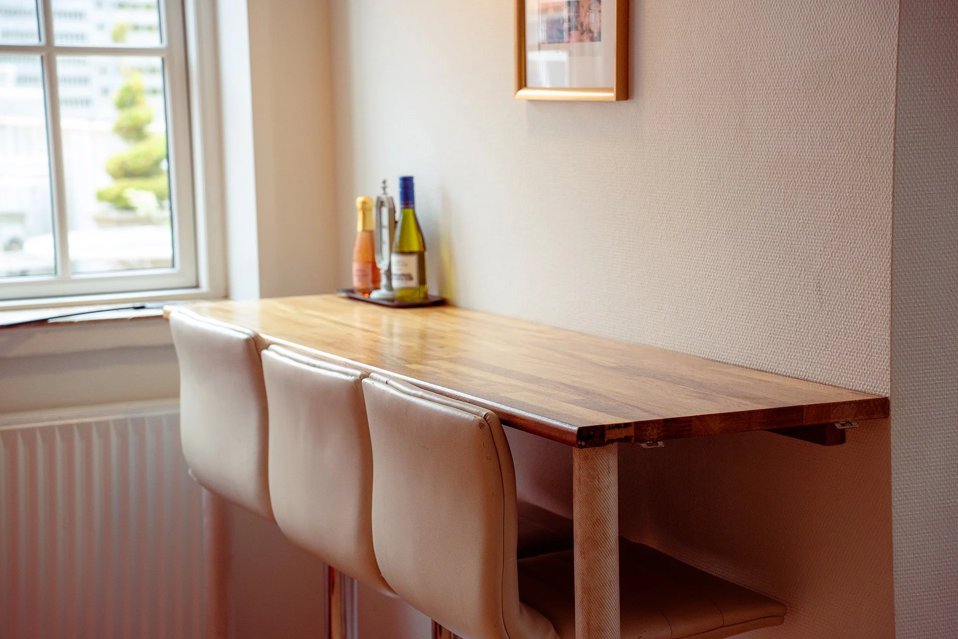 Spisebord med vin, vinduesudsigt, lyse stole