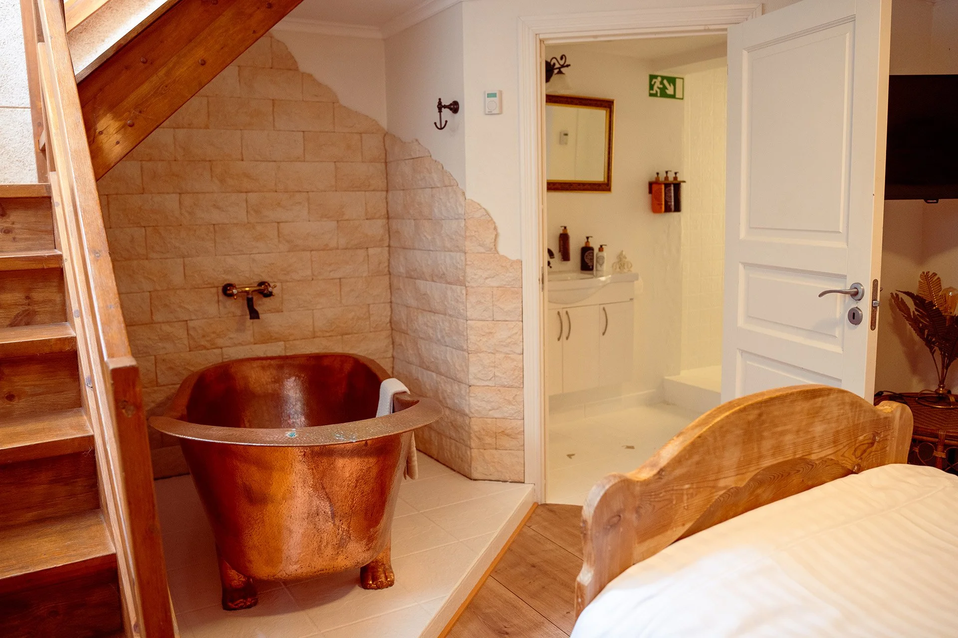 Kobber badekar, loftstrappe, stenmur, træseng