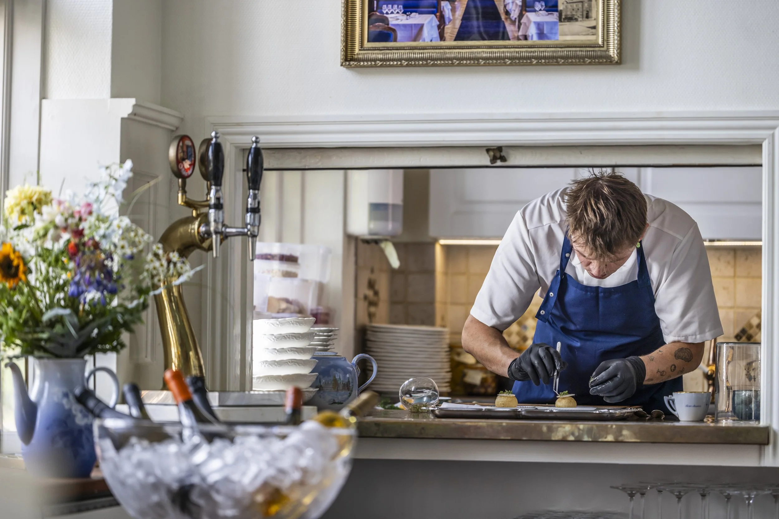 Kok i køkken igang med at anrette i Det Blaa Tog restaurant