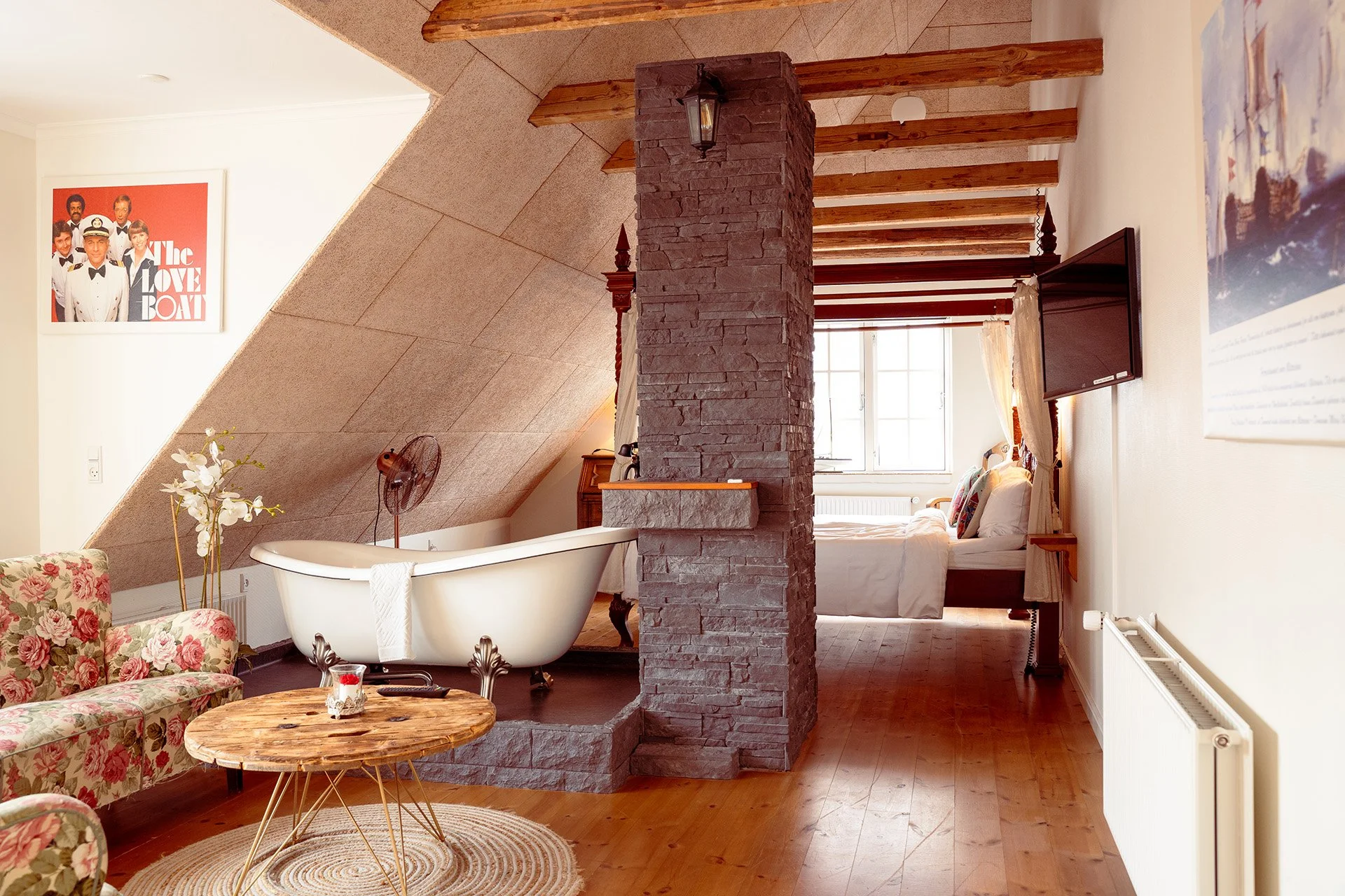 Kahyt suite, fritstående badekar, blomstret sofa, åbne bjælker