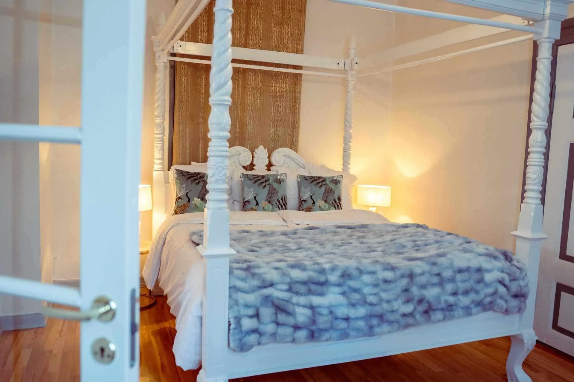 Romantisk værelse, hvid himmelseng, blå tæppe, damask tapet, aftenstemning