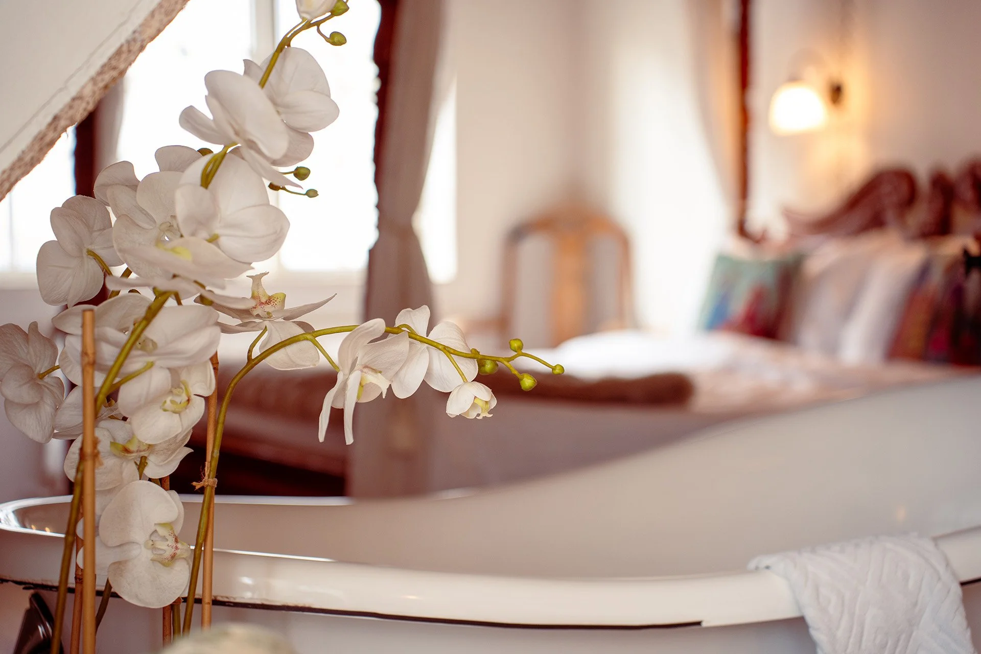 Hvide orkideer detalje, fritstående badekar, himmelseng baggrund