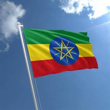 Ethiopisk flag flyver i blå himmel.