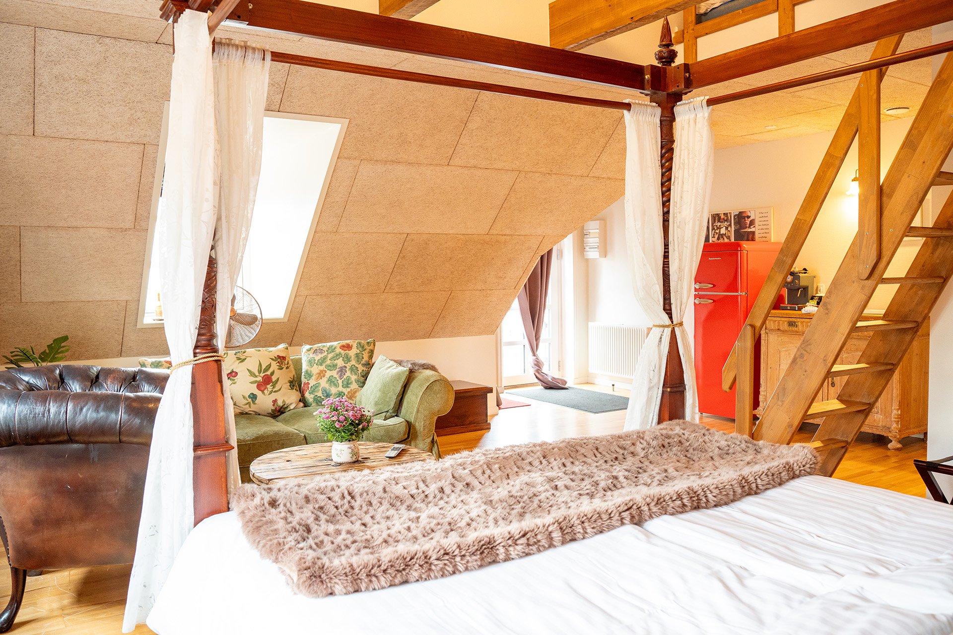 Suite overblik, himmelseng, rød køleskab, grøn sofa