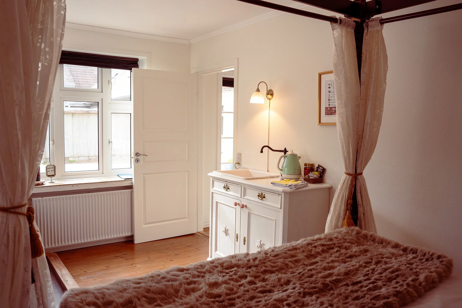 Hvidt køkkenskab, elkedel, pelstæppe, mansardvindue