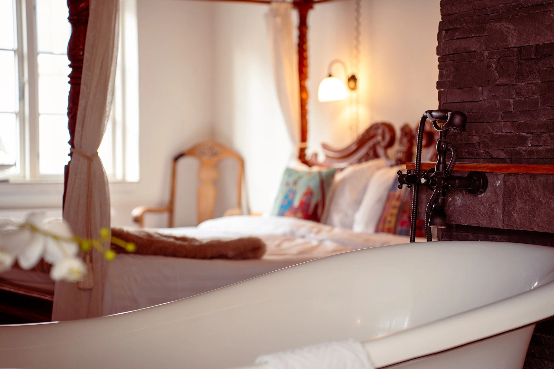 Fritstående badekar detalje, himmelseng, stenmur, sengelampe