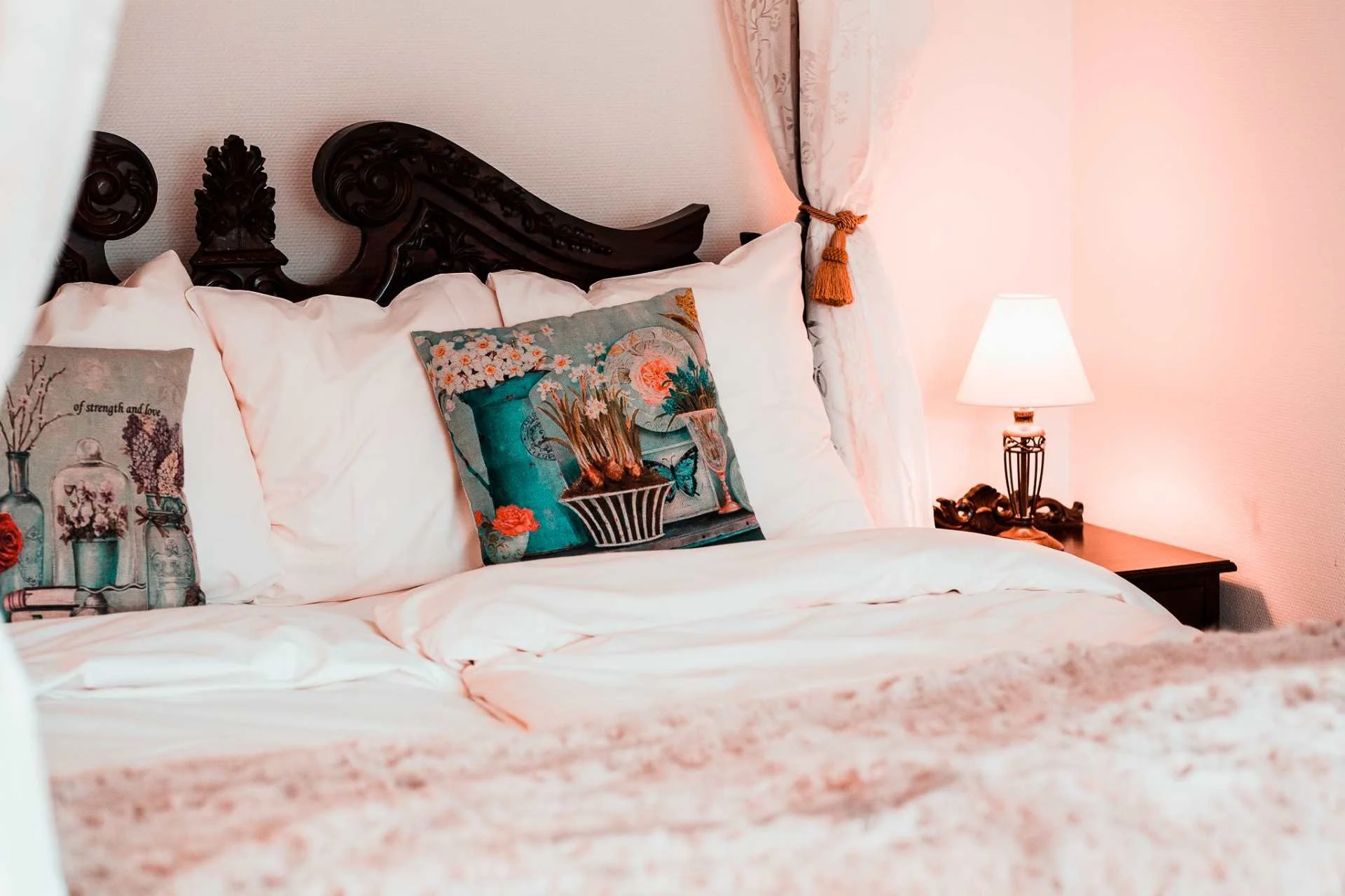 H.C. Andersen Suite, udskåret mørk sengegavl, blomstrede puder, sengelampe