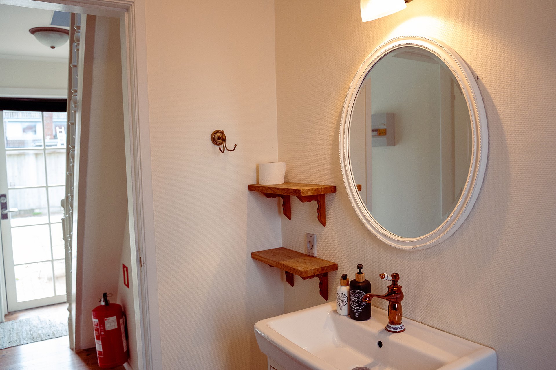 Badeværelse, ovalt spejl, håndvask, træhylde