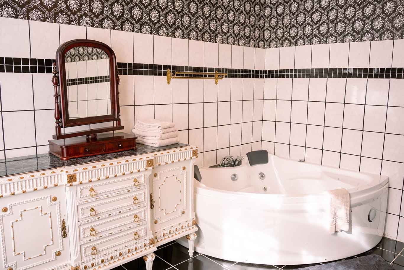 Antikt badeværelse, jacuzzi, ornamenteret hvidt kommode, spejl
