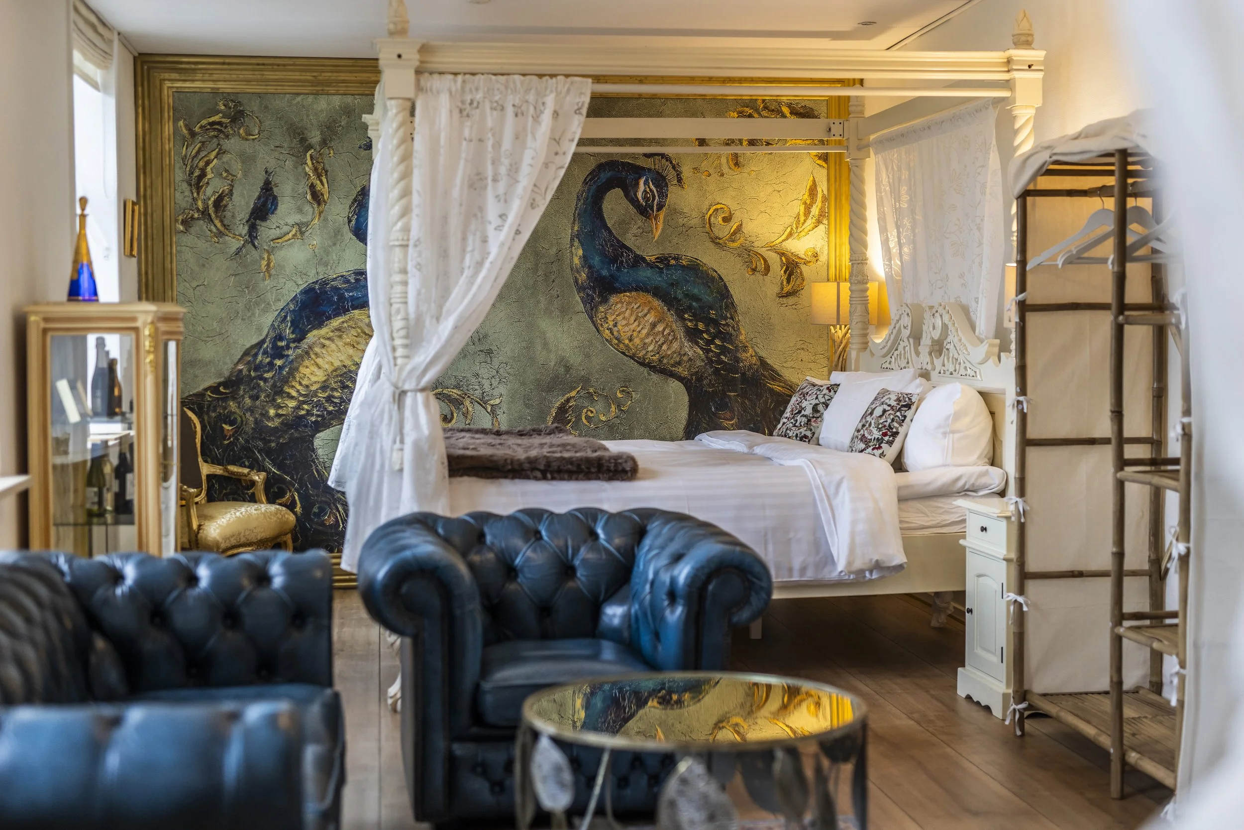 Luksussuite med blå fløjl sofa himmelseng Postgården