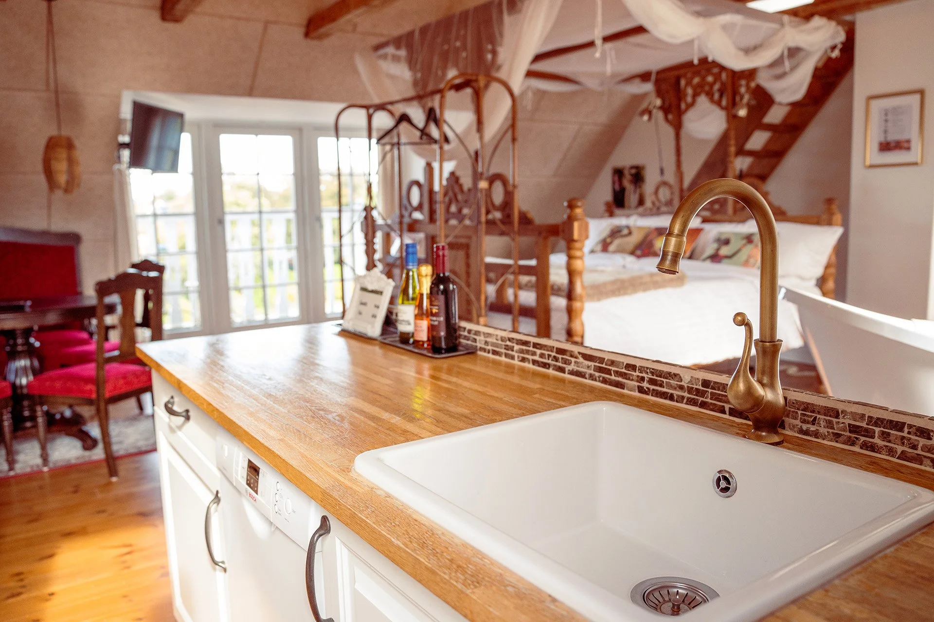 Køkken håndvask, messing armatur, træbordplade, himmelseng baggrund