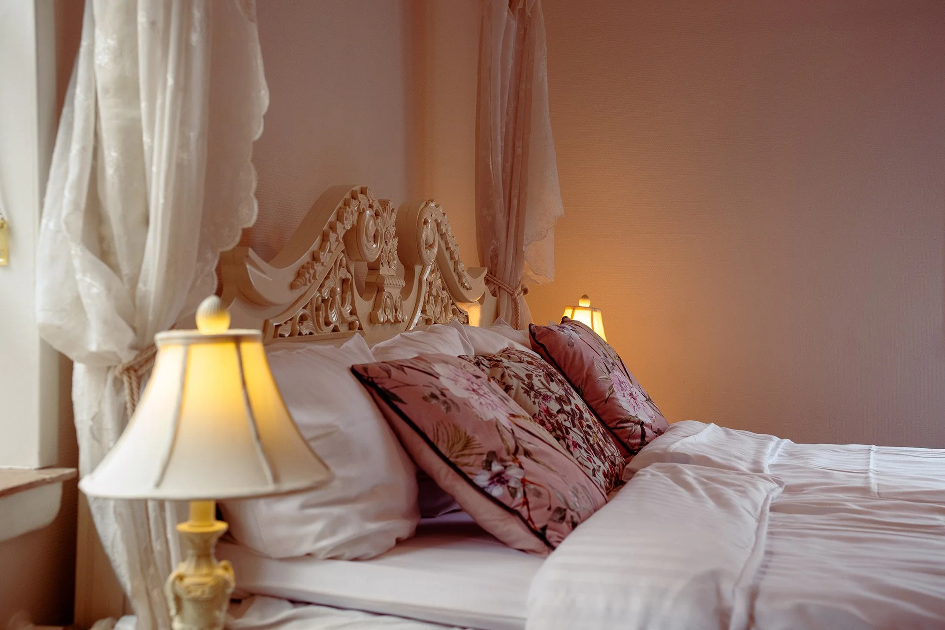 Hvid himmelseng, rosa puder, pelstæppe, lyst værelse