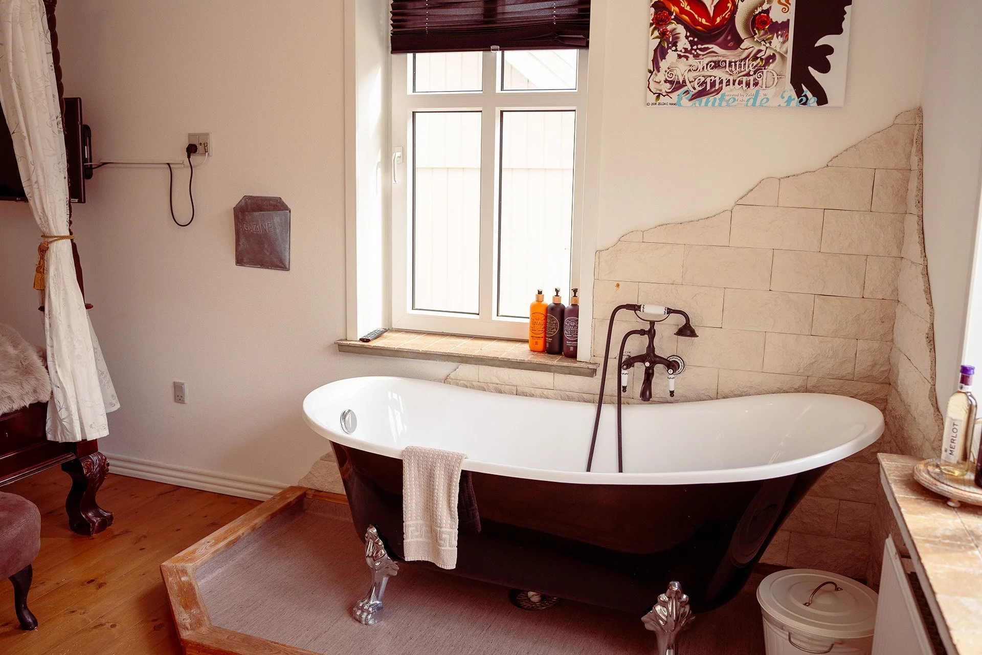 Fritstående badekar, vintage vandhane, stenmur, vindue