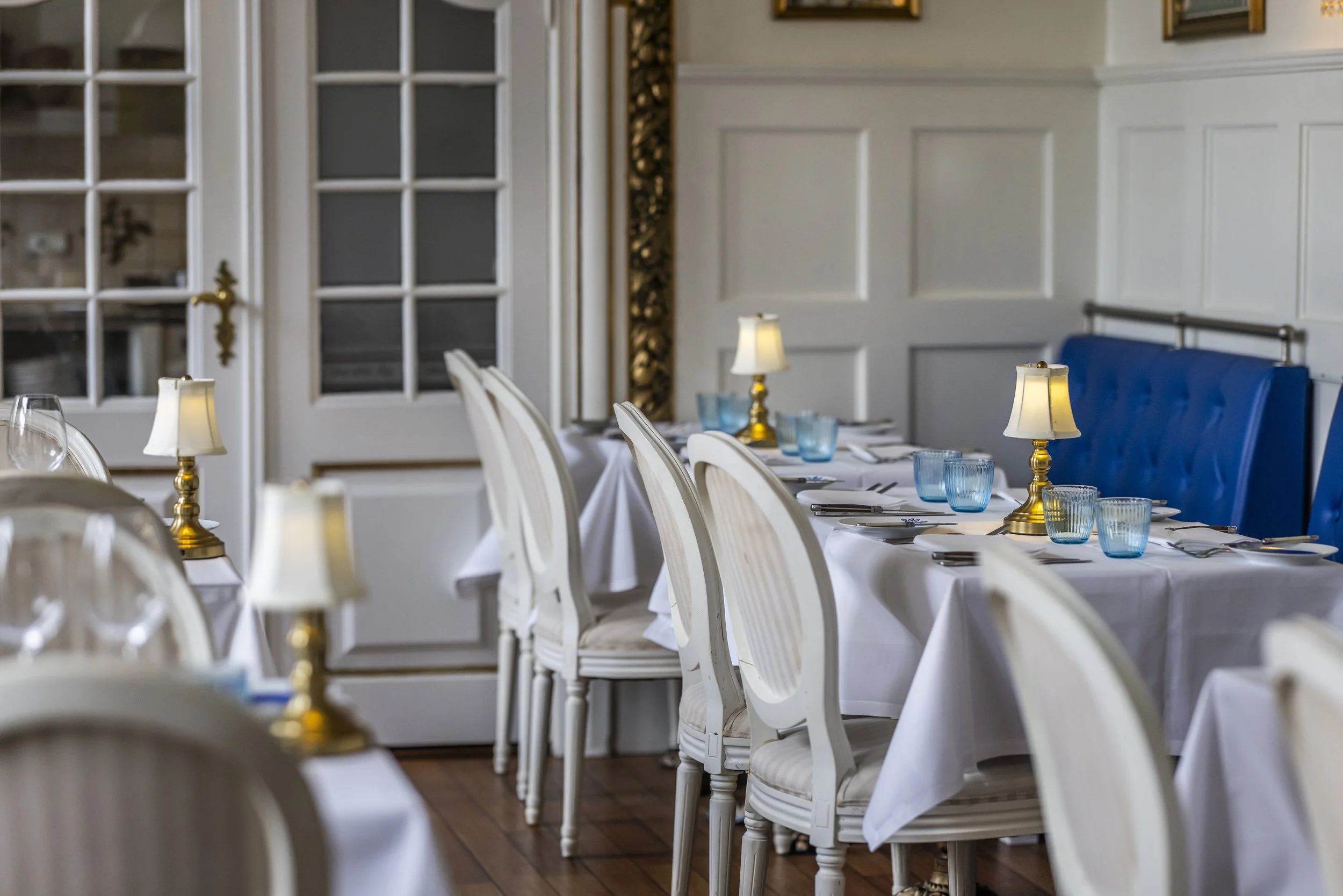 Elegant hvid restaurantsal blå detaljer Boutique Hotel Postgården