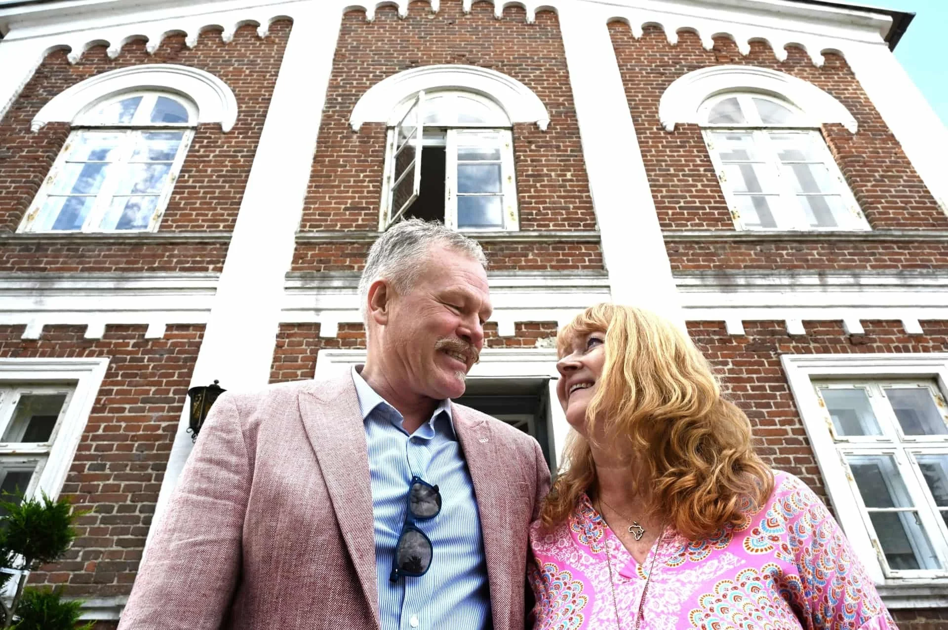 Suzette og Bjarne foran Postgårdens røde mursteinsfacade, ejerne af Boutique Hotel Postgården