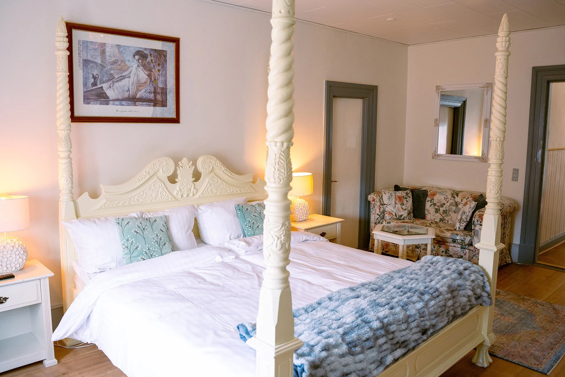 Hvid himmelseng, blåt tæppe, blomstret sofa, Dommersuiten