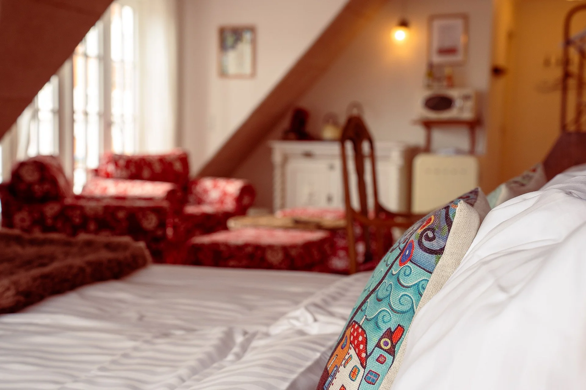 Himmelseng med farverige puder, røde lænestole baggrund