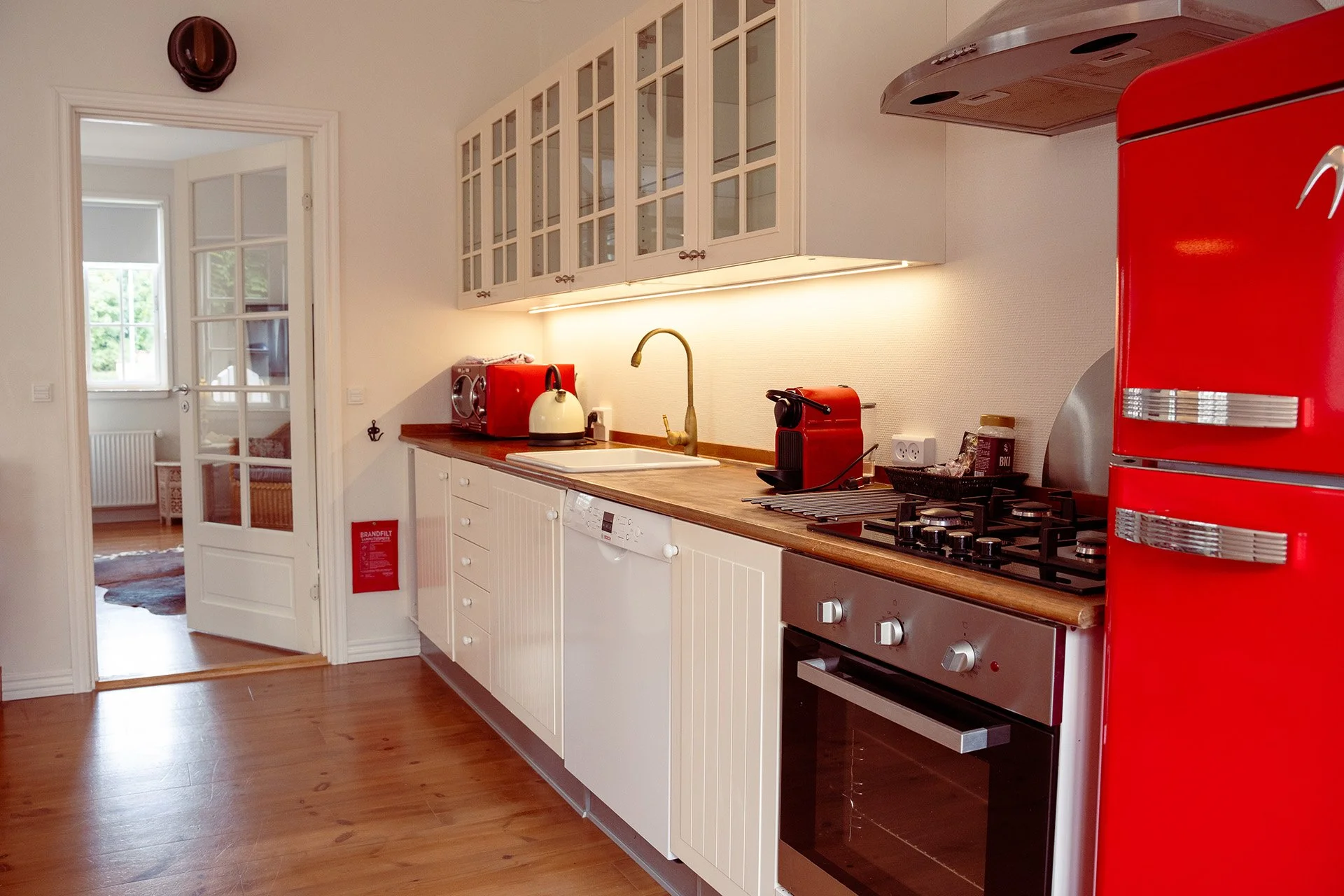 Hvidt køkken, rød køleskab, elkedel, franske døre