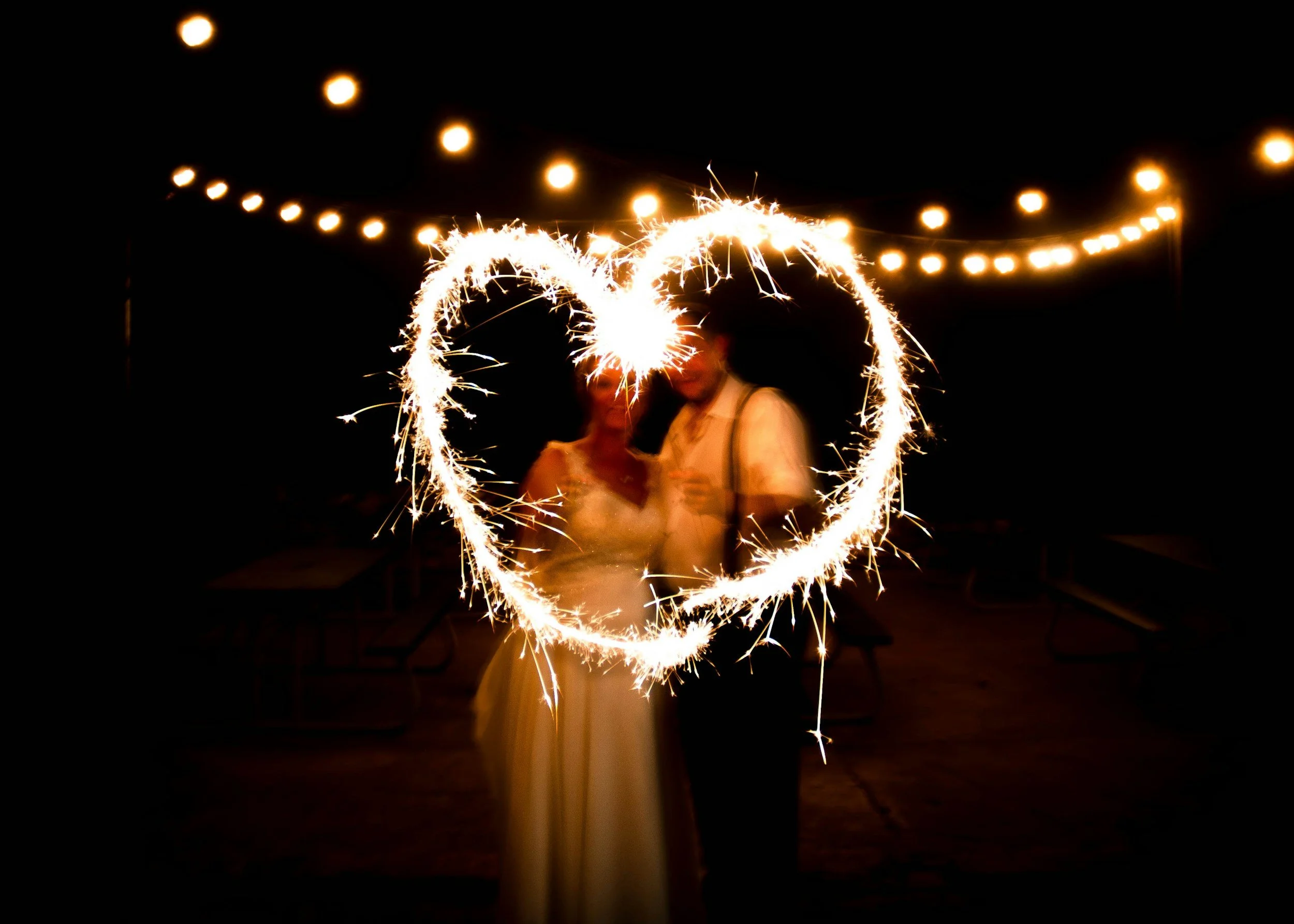 Couple creating a heart shape with sparkler