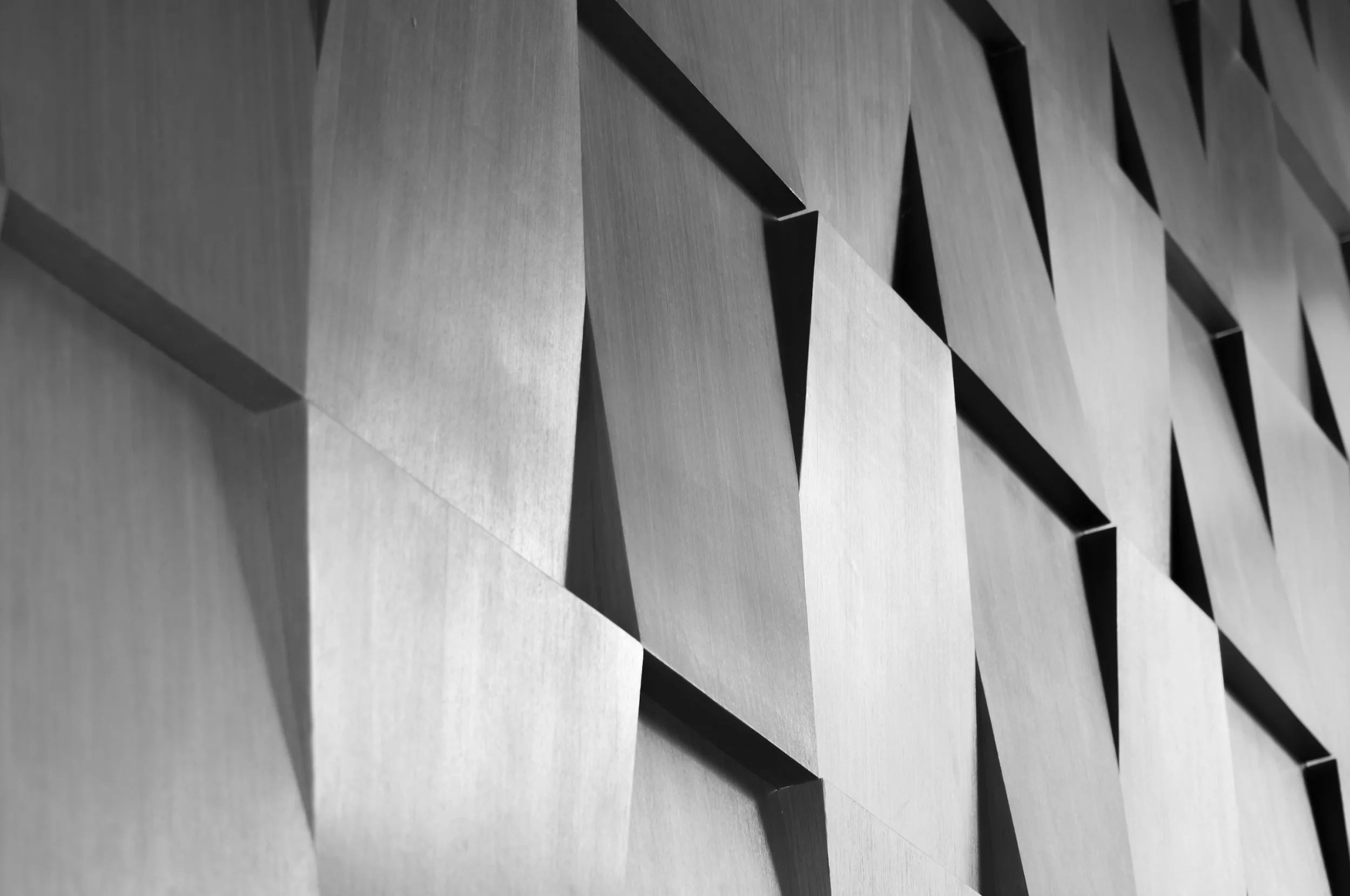 Close-up view of geometric wooden wall panels with angular cut-outs.