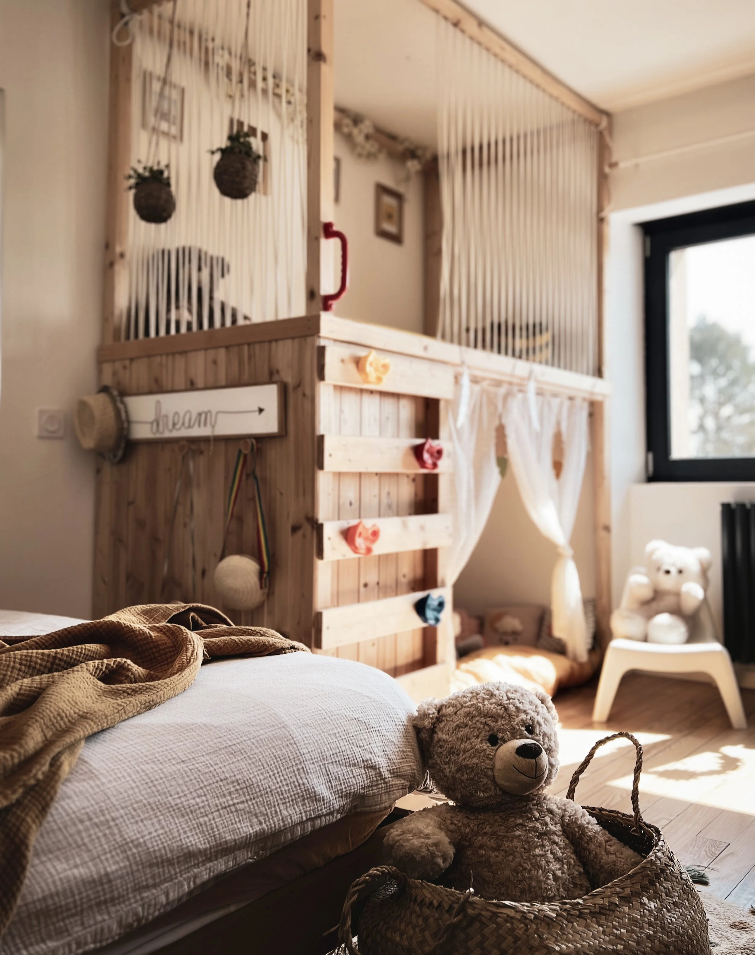 Chambre d’enfant avec cabane et coin lecture mezzanine en bois, décoration douce et chaleureuse, aménagement intérieur.