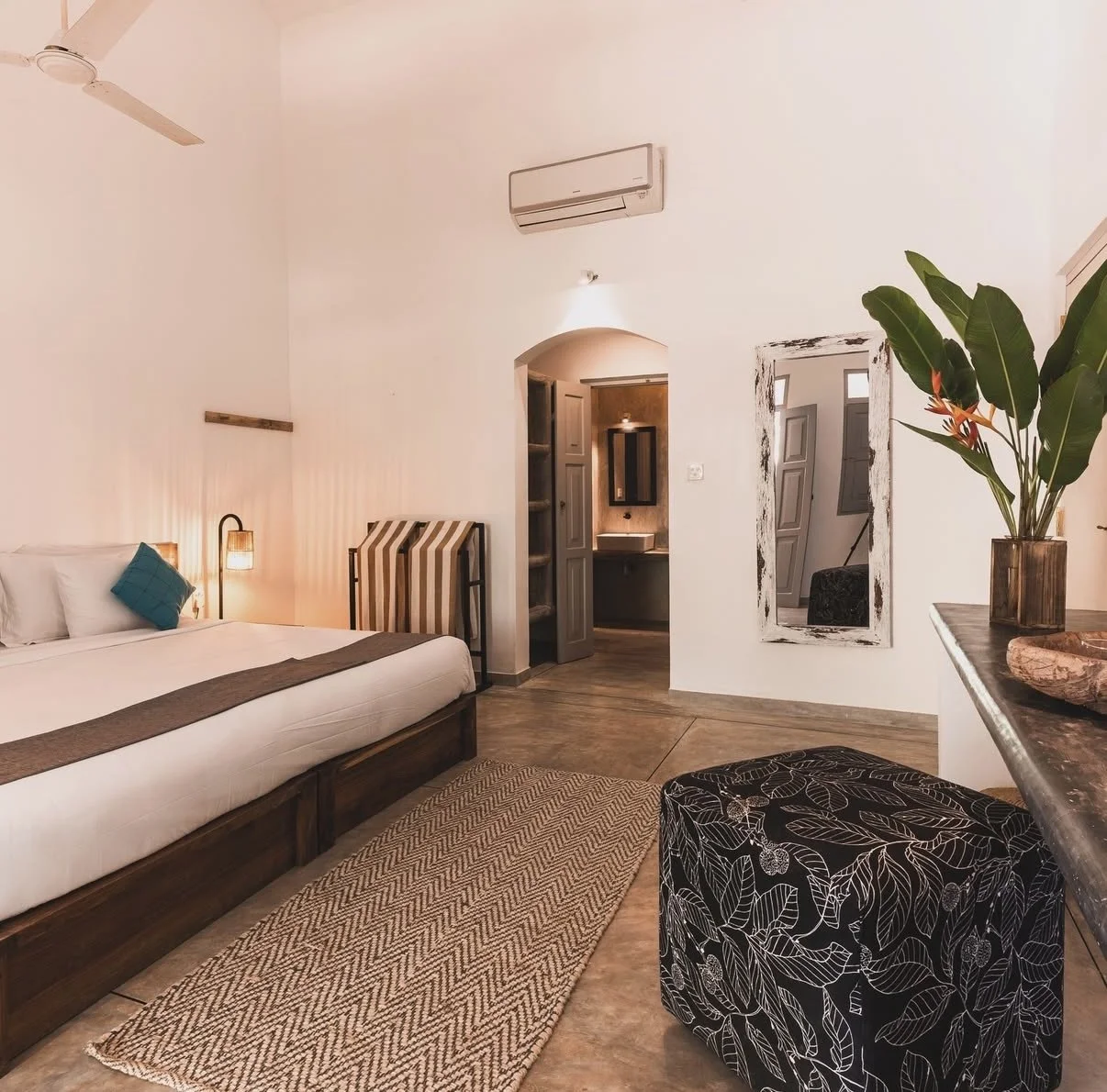 Close-up of two pillows with beige and brown striped fabric on a neatly made bed in a well-lit room.