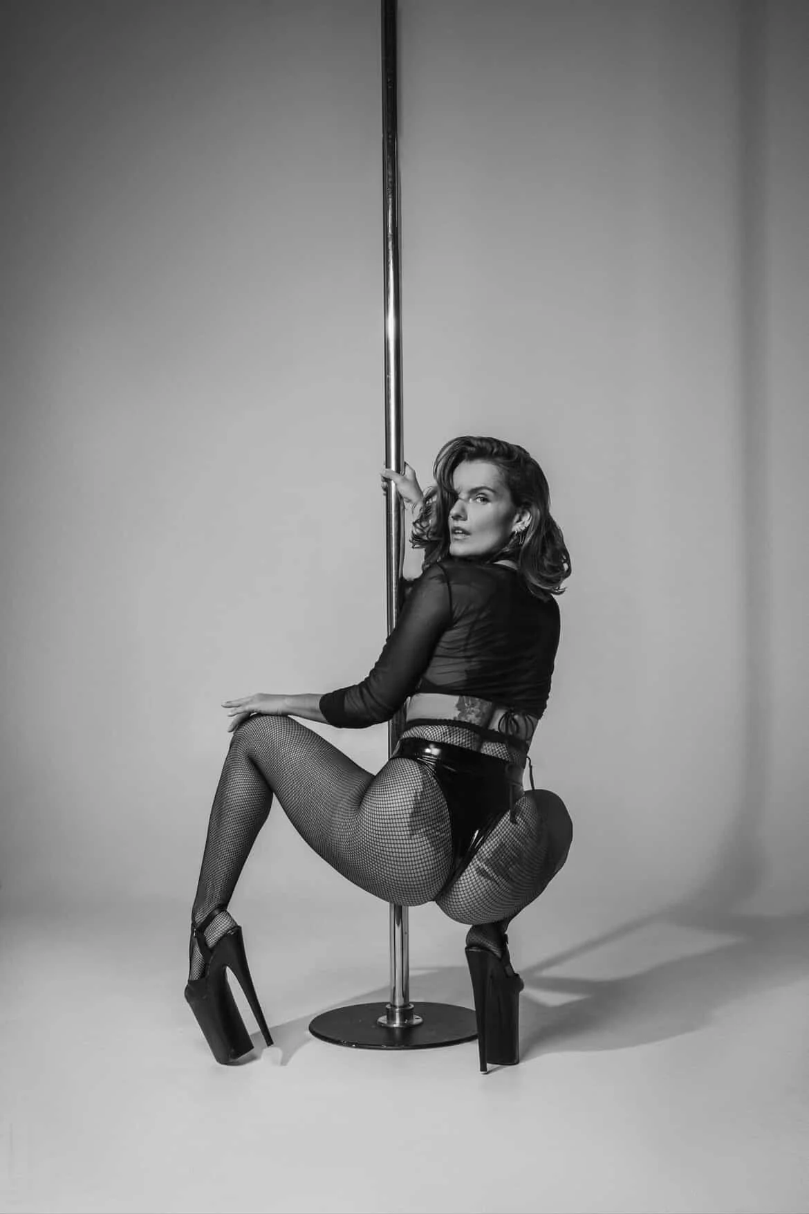 Woman practicing yoga in a side plank pose with one hand on the ground and the other arm extended.