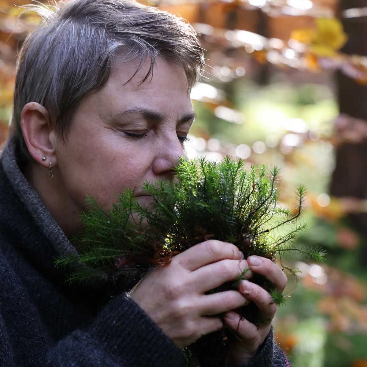 Kvinde falder helt til ro i skoven, under sansebad og føler sig velkommen.